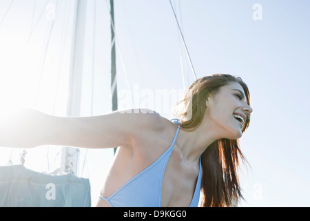 Bruna giovane donna su yacht, ridendo Foto Stock