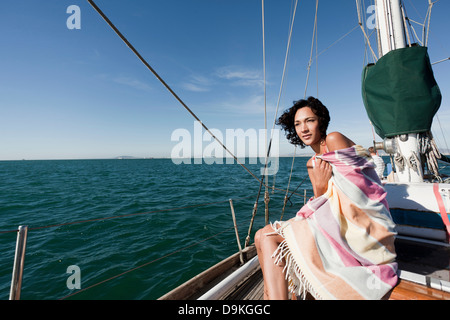 Giovane donna su yacht avvolto in una coperta Foto Stock