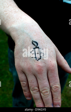 Amnesty International logo tatuaggio temporaneo su un lato Foto Stock