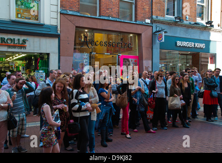 La gente ascolta buskers giocare Grafton Street central Dublino Irlanda Europa Foto Stock