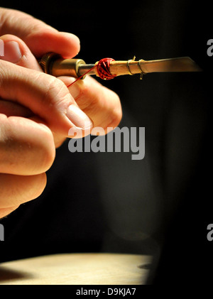 Il legame del fagotto reed con cotone rosso filettatura dopo essiccamento su rack Foto Stock