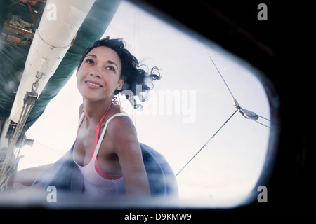 Giovane donna su yacht cercando Foto Stock