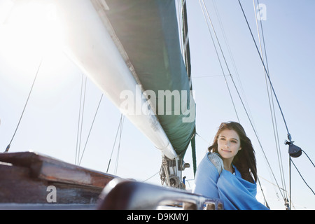 Bruna giovane donna su yacht avvolto in una coperta Foto Stock