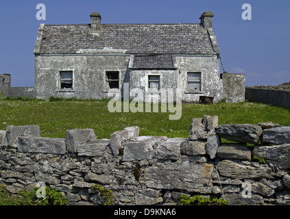 Piccolo cottage e impilati recinzione in pietra in Kilronan,Isole Aran,l'Irlanda Foto Stock