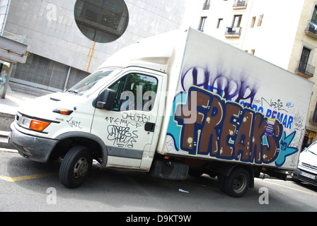 Strada urbana scena con soggetto ad atti vandalici coperto di graffiti minivan parcheggiato lungo Las Ramblas di Barcellona Foto Stock