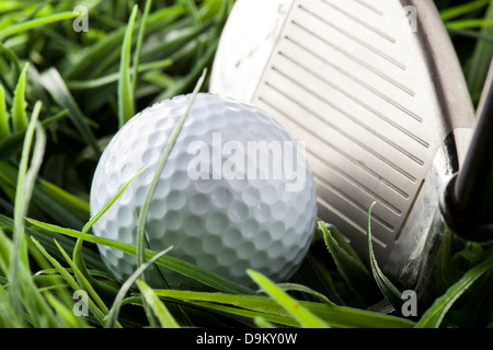 Bianco puro Golfball sul luminoso verde erba con un golfclub Foto Stock