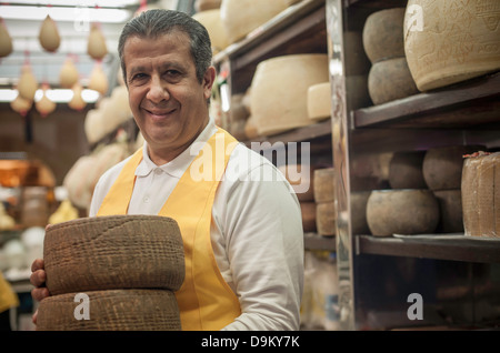 L uomo nel negozio di formaggi Foto Stock