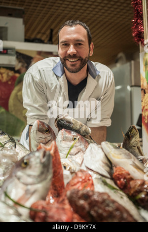 Pescivendolo maschio nel mercato Foto Stock