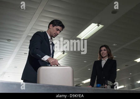 Gli imprenditori in aeroporto presso il reclamo bagagli Foto Stock