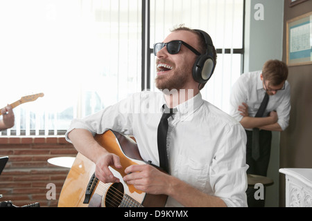 Giovane chitarrista ridere in sala prove Foto Stock