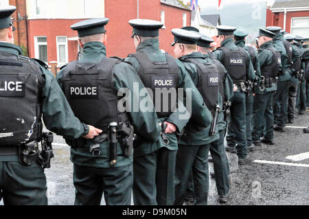 Uniformata PSNI gli ufficiali di polizia che indossa giacche ad alta visibilità formano una linea attraverso una strada per fermare una folla dal procedimento Foto Stock