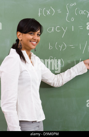Giovani indiani attraente insegnante di matematica di fronte di Blackboard Foto Stock