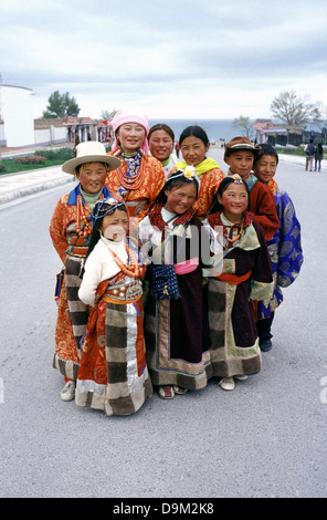 Un gruppo di giovani buddisti tibetani indossando il tradizionale indumento in lago di Qinghai noto anche come Koko Nur o Kukunor nella Provincia di Qinghai Cina Foto Stock