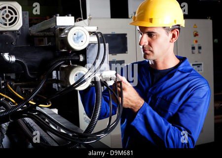 Moderna macchina industriale operatore lavorando sulla macchina Foto Stock