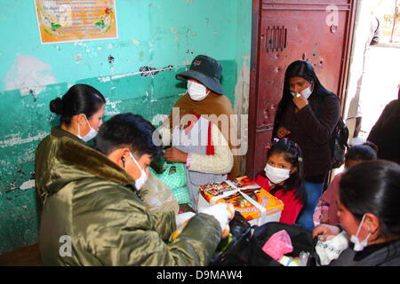 La Paz in Bolivia. Il 22 giugno 2013. Una ragazza attende con una torta di compleanno mentre la polizia cerca sua madre beni prima di visitare i parenti rinchiuso nella prigione di San Pedro in carcere. Foto Stock