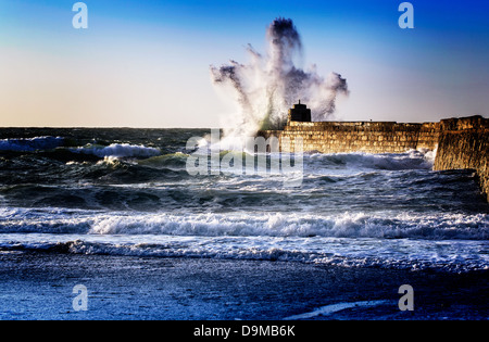 Presto le tempeste estive ha colpito la banchina a Porto Portreath fantasma di formatura come le forme delle onde Foto Stock