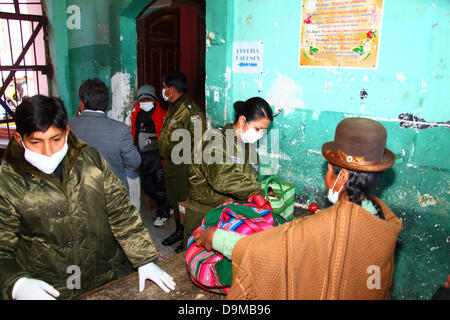 La Paz in Bolivia. Il 22 giugno 2013. Una donna Aymara o cholita ha i suoi averi cercato dalla polizia prima di visitare i parenti rinchiuso nella prigione di San Pedro in carcere. Foto Stock