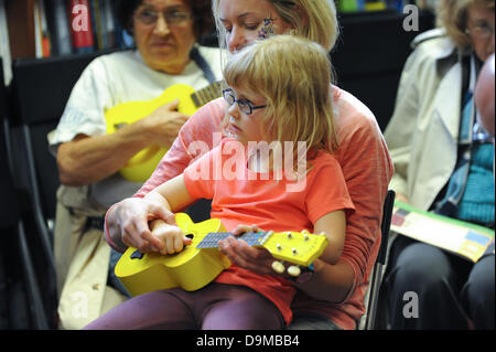 Blackwells Bookshop, Charing Cross Road, Londra, Regno Unito. Il 22 giugno 2013. Una giovane ragazza apprende l'ukulele al 'Ukulele parte" in Blackwells bookshop un'attività come parte del Charing Cross Road Fest 2013. Credito: Matteo Chattle/Alamy Live News Foto Stock