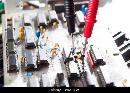 Multimetro il test di una scheda di circuito Foto Stock