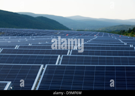 Il sole tramonta su un campo di pannelli solari vicino al completamento installazione in Adams, Massachusetts. Foto Stock