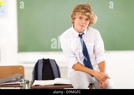 Alta scuola teen boy studente seduto sulla scrivania in aula Foto Stock