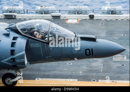 US Marine Corps magg. pilota Gregory Boyington saluta il segnalatore di atterraggio dal suo AV-8B Harrier fighter aircraft prima del decollo dall'assalto anfibio nave USS Bonhomme Richard Giugno 20, 2013 nel Mar Cinese Orientale. Foto Stock