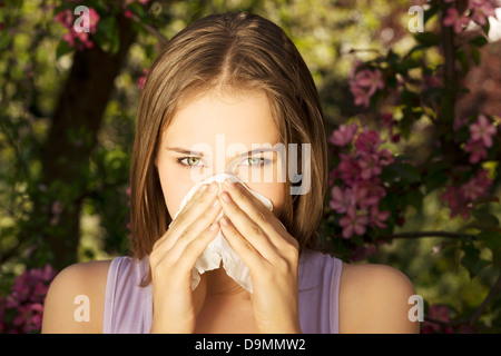 Giovane donna con allergia durante la giornata di sole è tergi naso. Foto Stock