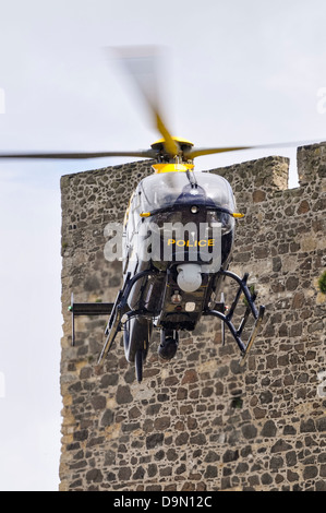 PSNI elicottero della polizia G-PSNI (Eurocopter EC135) giunge in terra accanto al Castello di Carrickfergus Foto Stock