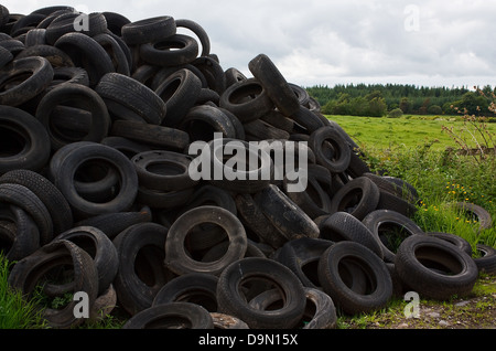 Pila di vecchi pneumatici del veicolo oggetto di dumping nella campagna dal contadino Foto Stock