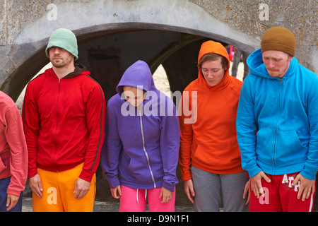 Bodies in Urban Spaces performer in coloratissime felpe in piedi presso Bournemouth Pier, Dorset UK, alla fine della loro esibizione in giugno Foto Stock