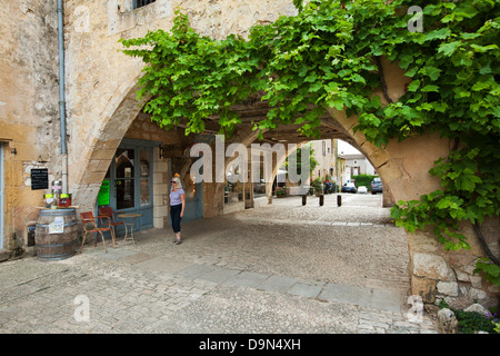 Uno dei molti archi con negozi e caffetterie nei dintorni di Place des Cornieres in Monpazier, Dordogne, Francia Foto Stock