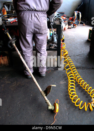 Meccanico nel garage che lavorano in un'auto Foto Stock