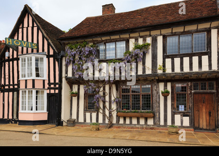 Il Glicine floribunda cresce su una casa in legno davanti al villaggio storico. Market Place, Lavenham, Suffolk, Inghilterra, Regno Unito, Gran Bretagna Foto Stock