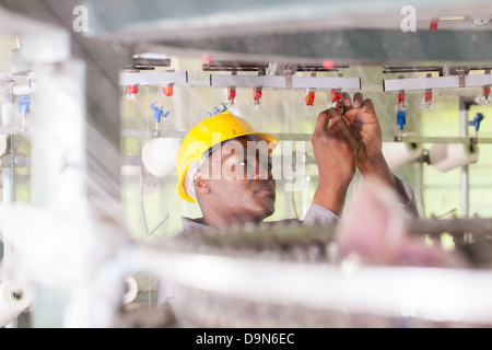 Americano africano collare blu lavoratore lavora nella fabbrica tessile Foto Stock