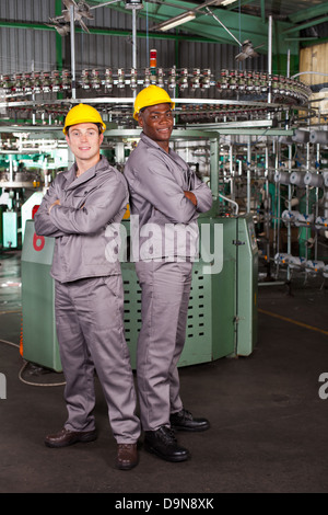 Due operai industriali a piena lunghezza ritratto in fabbrica Foto Stock