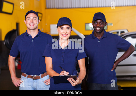Gruppo di lavoratori felice nel negozio di riparazioni auto Foto Stock