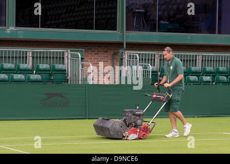 Londra, Regno Unito. Il 23 giugno, 2013. Il torneo di Wimbledon Tennis Championships 2013 tenutosi presso il All England Lawn Tennis e Croquet Club di Londra, Inghilterra, Regno Unito. Vista generale (GV). Un uomo motivi mows l'erba del n. 18 Corte in preparazione per l'inizio dei campionati di domani. Credito: Duncan Grove/Alamy Live News Foto Stock