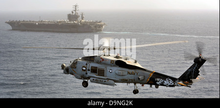 US Navy MH-60R Sea Hawk elicotteri volare oltre la portaerei USS Nimitz Giugno 21, 2013 nel Golfo di Oman. Foto Stock