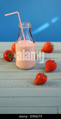 Frullato di fragole con fragole su sfondo blu Foto Stock