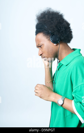 African adolescente americano in camicia verde con ascoltare musica Foto Stock