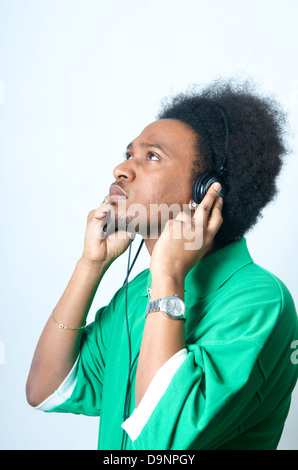 African adolescente americano in camicia verde con ascoltare musica Foto Stock