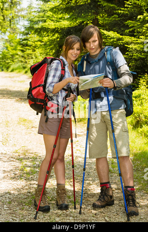 Giovane escursionista giovane permanente e la verifica della mappa in natura Foto Stock