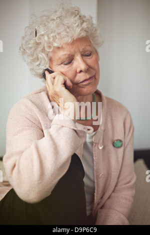 Nonna utilizzando un telefono cellulare per comunicare Foto Stock