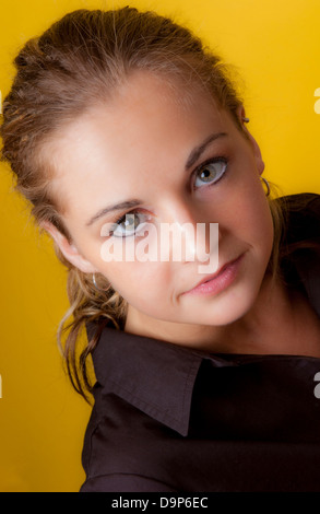 Testa di una giovane femmina caucasica su sfondo giallo Foto Stock