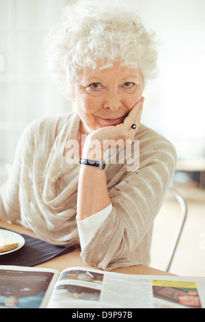 Ritratto di una donna senior guardando a voi con la mano sul mento Foto Stock