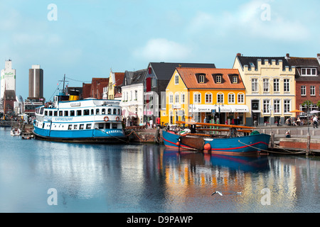 Il vecchio porto di Husum con piccole e grandi navi, turisti e negozi in background Foto Stock
