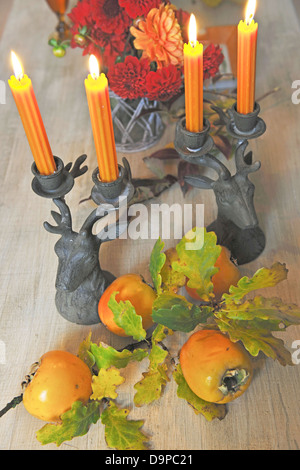 Mazzo di fiori, il candelabro e kakis Foto Stock