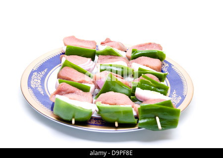 Carni fresche sputa con le verdure su una piastra di plastica Foto Stock