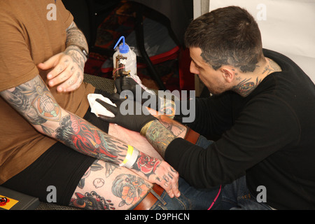 Tattooist funzionante a Brighton Tattoo Convention Foto Stock