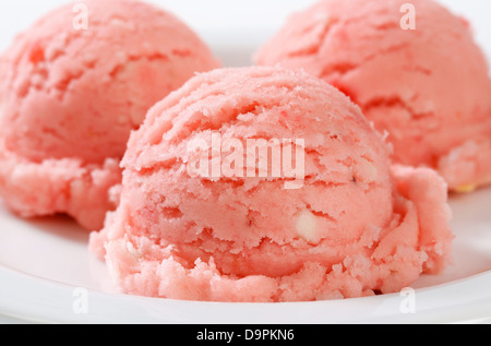 Tre palline di sorbetto rosa sulla piastra Foto Stock